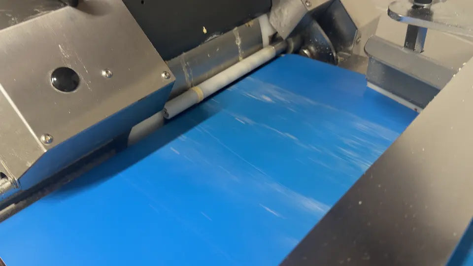 Dough moving from a machine onto a conveyor in the Great Balls of Flour bakery
